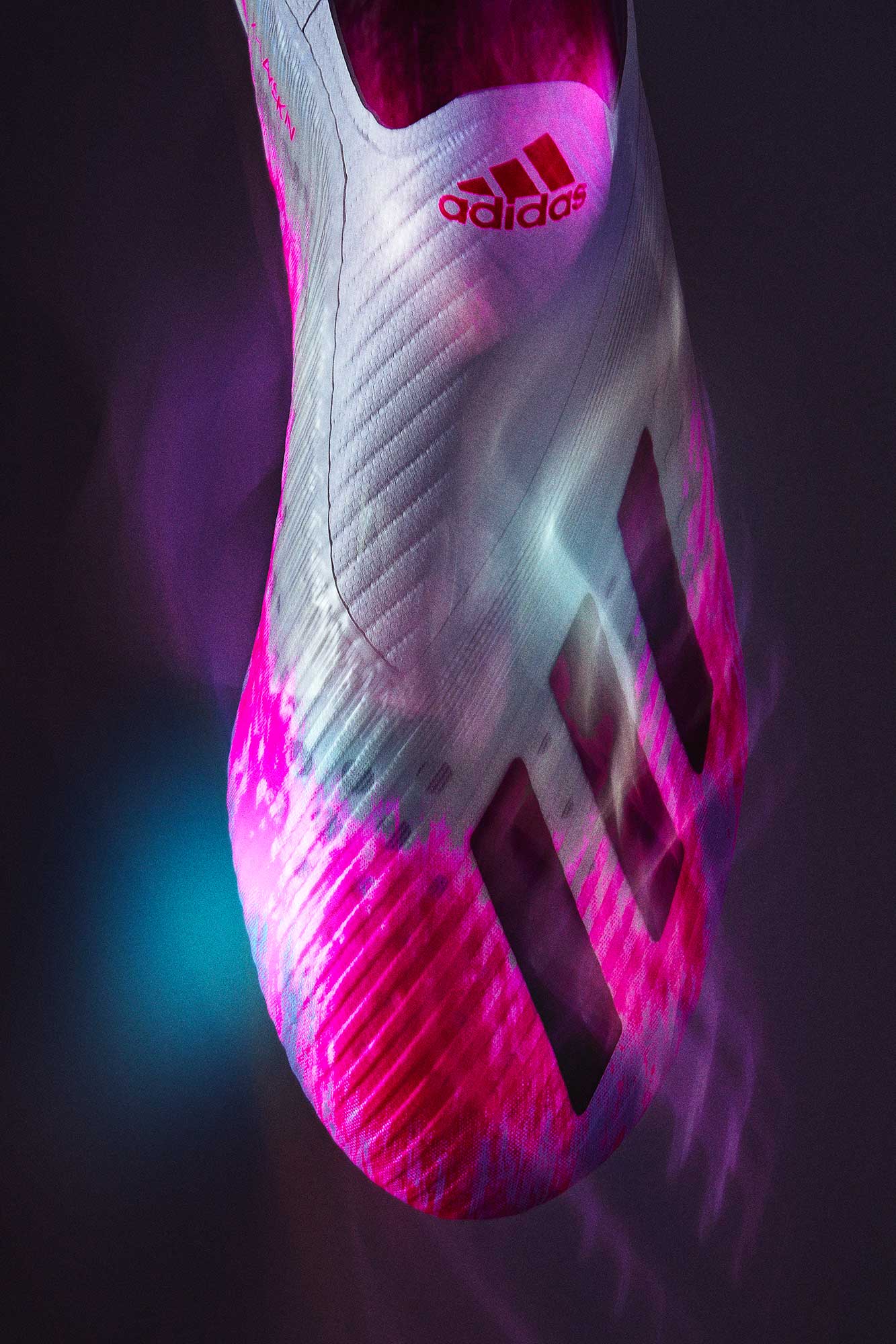 pink adidas football boot commercially photographed in studio using motion blur to create a story of speed and agility