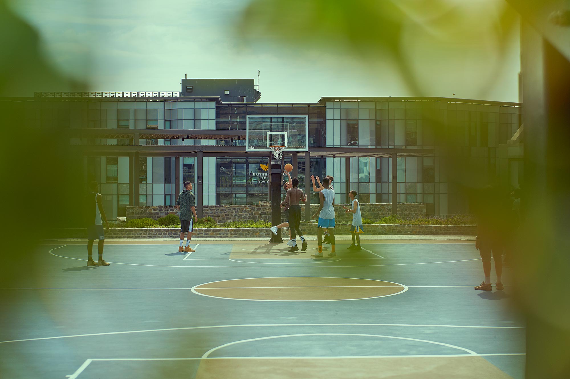 Tissot T-Touch Connect, a new Swiss watch, is showcased in an outdoor setting on a hard court basketball court. The image features basketball players engaged in a game, illuminated by natural lighting. The photograph captures the dynamic and energetic atmosphere, highlighting the watch's sleek design and innovative features, perfectly combining style and functionality